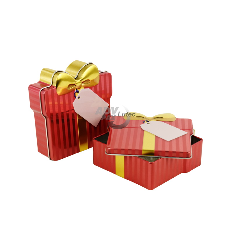 Schmuckdose Geschenkdose rot gestreift mit goldener stilisierter Schleife, Weißblechdose halb geöffnet im Vordergrund liegend, zweite geschlossen stehend