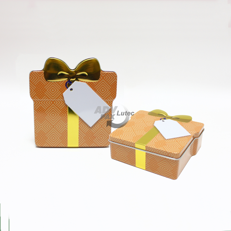 Schmuckdose Geschenkdose orangenes Muster mit goldener stilisierter Schleife, Weißblechdose Draufsicht stehend, zweite Dose liegend, geschlossen