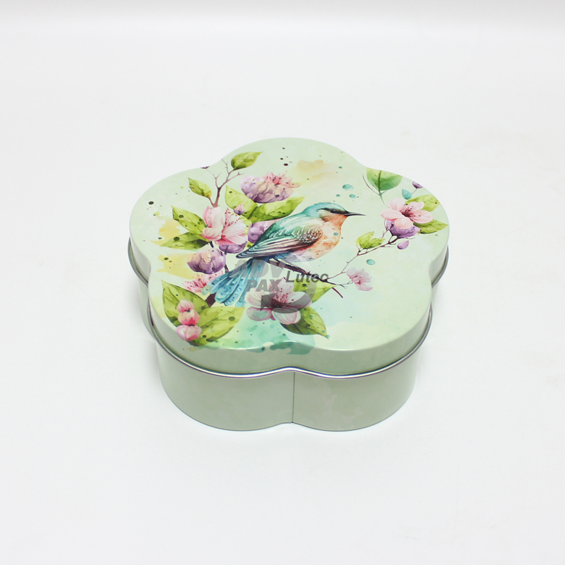 Korbdose mit Frühlingsmotiv und Singvogel als Geschenkverpackung für Ostern. Stülpdeckeldose in Blütenform aus Weißblech. Draufsicht auf Deckel